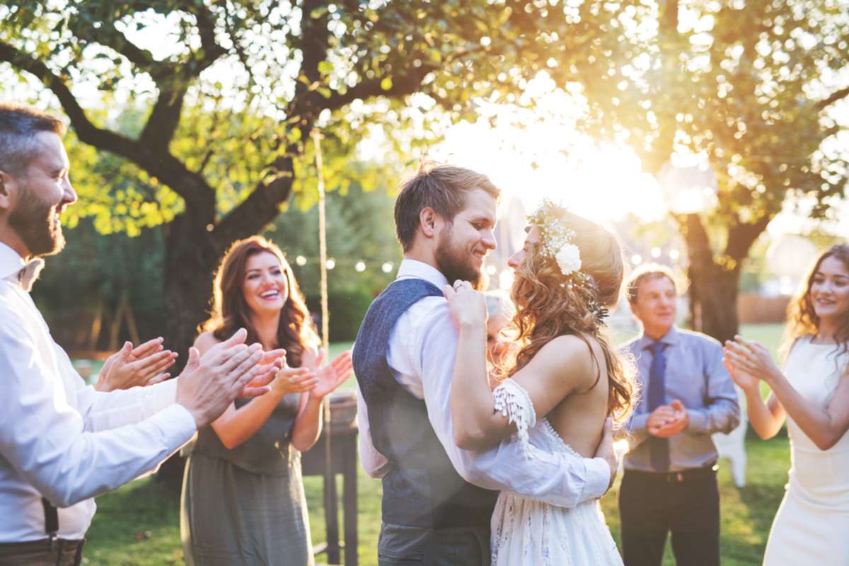 Bride and groom dancing at wedding reception outside in the backyard